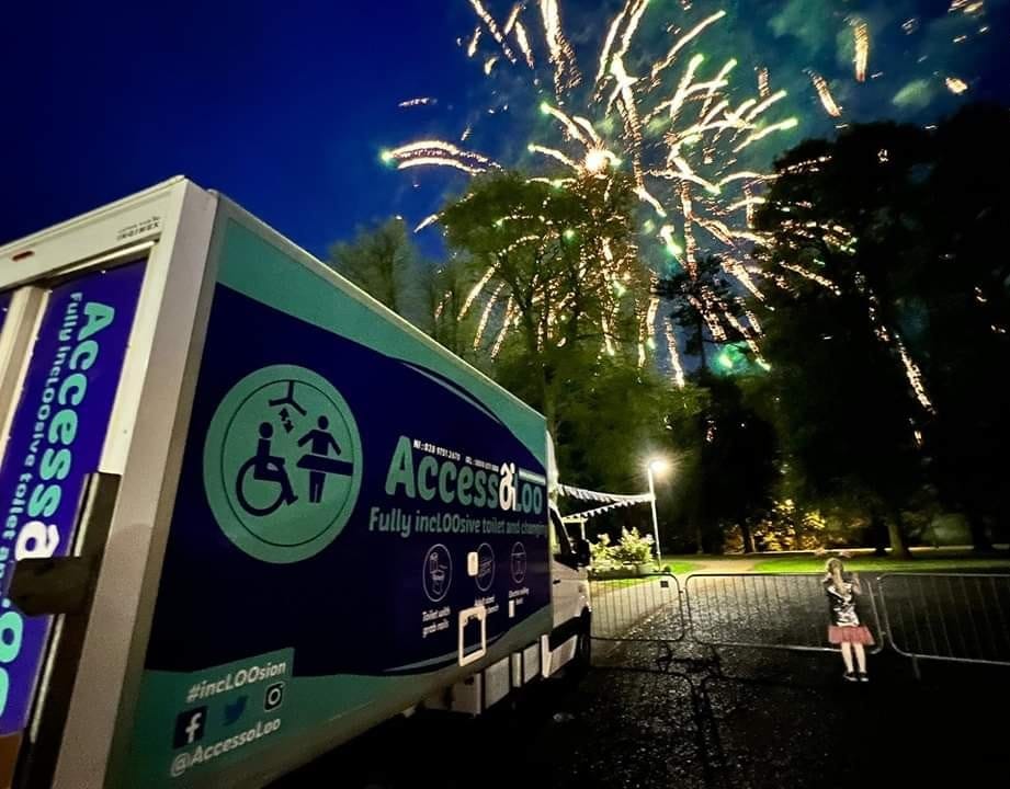 AccessoLoo Michaela parked on a dark Autumn evening with Fireworks exploding in the night sky in the background