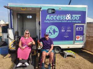 Michael and a service user outside AccessoLoo Lilia on a sunny day at Boardmasters